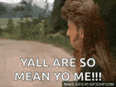 a man with long hair is standing on a dirt road and saying `` yall are so mean yo me '' .