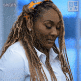 a woman with braids is wearing a white shirt and a be icon