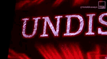 a man is standing in front of a sign that says undis