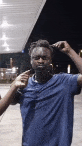 a man in a blue shirt is being brushed by another person