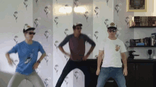 three young men are dancing in front of a wall that has flowers on it