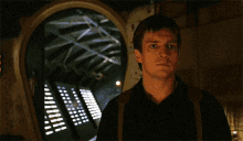 a man in a black shirt is looking through a doorway at a computer screen