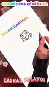 a person is writing on a piece of paper that says " salam cakrai "