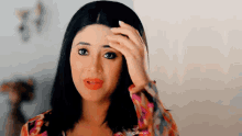 a woman is holding her hand to her forehead .