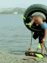 a man wearing a mask and flippers is holding a tire