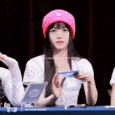 a girl wearing a pink hat is sitting at a table with day star written on the bottom
