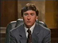 a man in a suit and tie is making a face