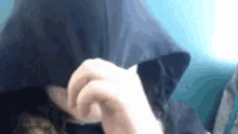 a person is covering their face with a hood .