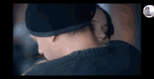 a man and a woman are hugging each other . the man is wearing a hat .