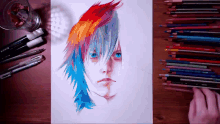 a drawing of a person 's face with colored pencils on a wooden table
