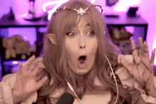 a woman wearing a wig and a crown is making a funny face .