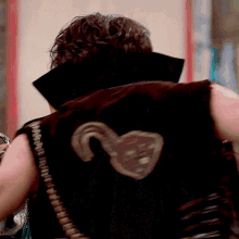 a man wearing a black vest has a hook on the back