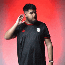a man with a beard wearing an adidas shirt