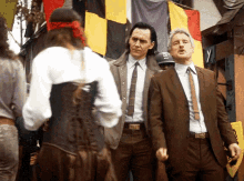 two men in suits are standing next to each other in front of a crowd .