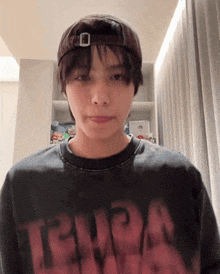 a young man wearing a hat and a t-shirt with the word tenda on it