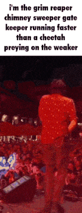a man in a red shirt is standing in front of a crowd and talking to them .