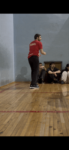 a man wearing a red shirt that says karate on the back