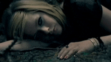 a woman laying down with her eyes closed and a ring on her finger