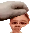 a hand is holding a person 's head and making a funny face .