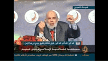 a man with a beard is speaking into a microphone on a television