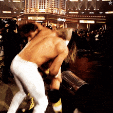 two men are wrestling in front of a building that has the word wrestlemania on it