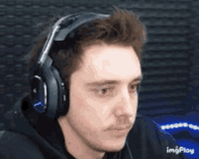 a man wearing headphones is looking at the camera and making a funny face .