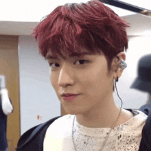 a young man with red hair is wearing earphones