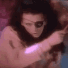 a woman with a pirate mask on her face is holding a sword in her hand .