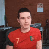 a man wearing a red shirt with the number 7 on the front