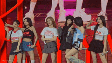 a girl wearing a shirt that says hello monsters stands on stage