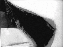 a black and white photo of a hole in a snowy surface
