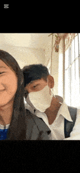 a man wearing a mask is standing next to a woman in a classroom .