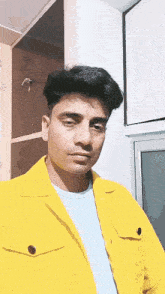 a man wearing a yellow jacket and a blue shirt