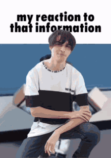 a man in a black and white shirt is kneeling down with the words " my reaction to that information " behind him