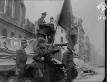 a black and white photo of a group of soldiers holding a flag