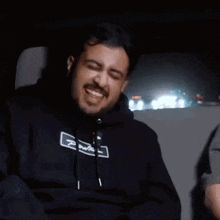 a man with a beard is sitting in the back seat of a car .