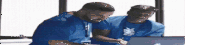 two men are looking at a laptop computer .