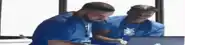 two men are looking at a laptop computer .