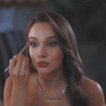 a woman applying makeup with minimalmoons written on the bottom of the image