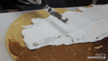 a person is spreading whipped cream on a pizza with the words made in animatica in the corner