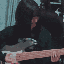 a person playing a bass guitar with a sticker on it that says fender