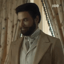 a man with a beard and mustache is wearing a suit and tie .