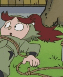 a cartoon character with red hair is tied up with a rope and laying on the ground .