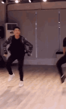 a man is dancing in a dance studio with another man .