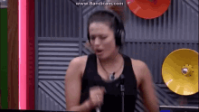 a woman wearing headphones is singing into a microphone