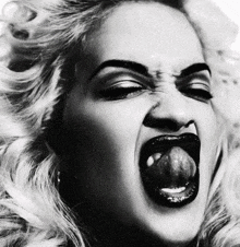 a black and white photo of a woman with her tongue out