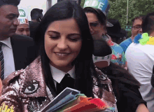 a woman wearing a bride hat smiles while holding a book