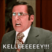 a man wearing glasses and a suit says kelleeeeey