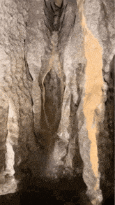 a waterfall in a cave with a lot of rocks and water coming out of it