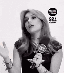 a woman is holding a microphone and talking into it .